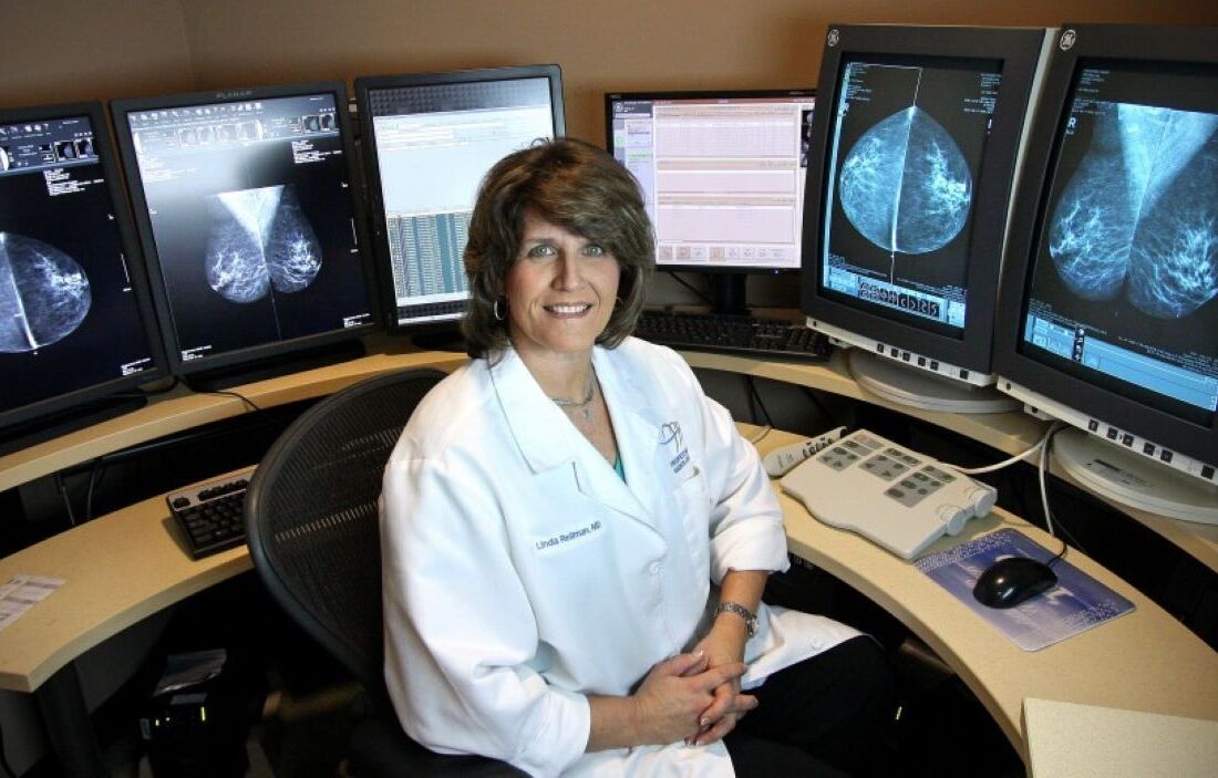 woman sitting in front of screens with scans